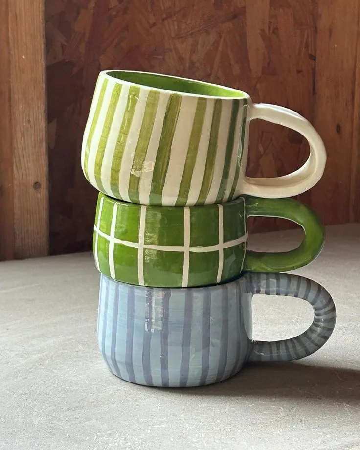 Stack of colorful ceramic mug with green and blue striped design
