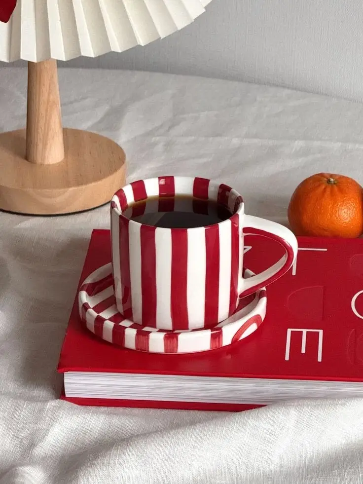 Red and white striped ceramic mug with saucer