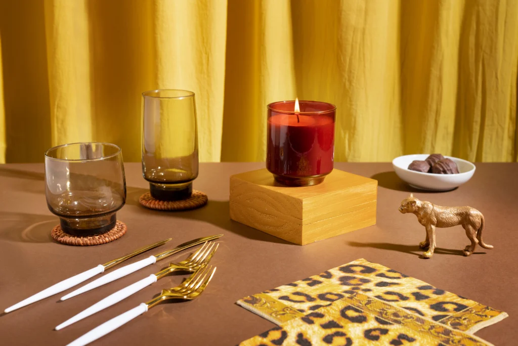 Maximalist home decor styles with bold tableware, golden cutlery, candle, and colorful decorative accents